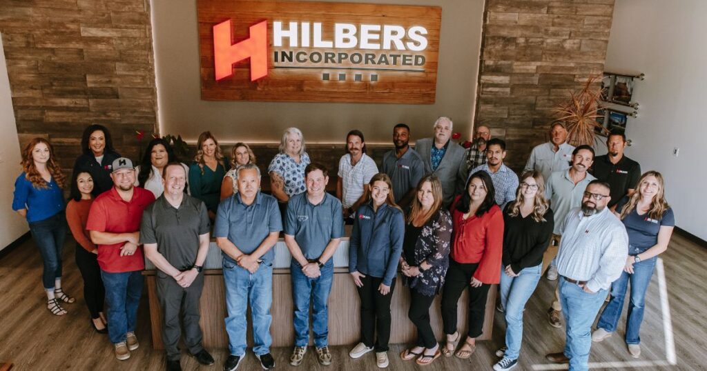 Hilbers team gathered together smiling for a group photo, representing their employee-owned company and spirit of gratitude during the Thanksgiving season.