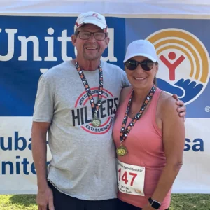 A couple posing in front of a United Way banner.