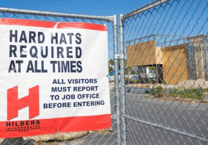 Sign reading “Hard Hats Required” at an active job site, reinforcing a strong safety culture and ongoing training for all team members.