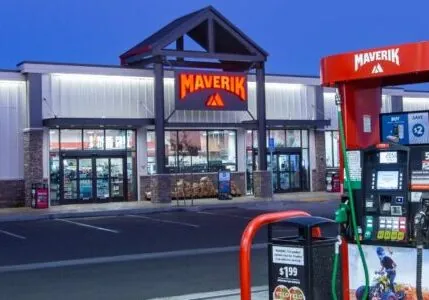 A red Maverik gas station pump at night. There is a Maverik store in the background.