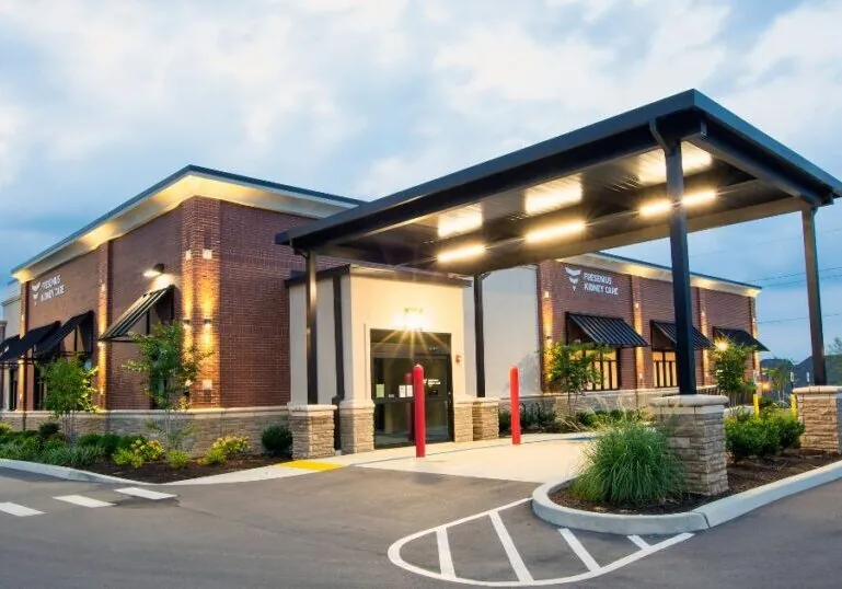 A Tennessee commercial construction project built by Hilbers for FKC in Spring Hill. The building is brick, and the lights are on as it is evening time.